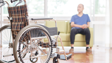 車椅子とベンチに座る中高年男性の写真